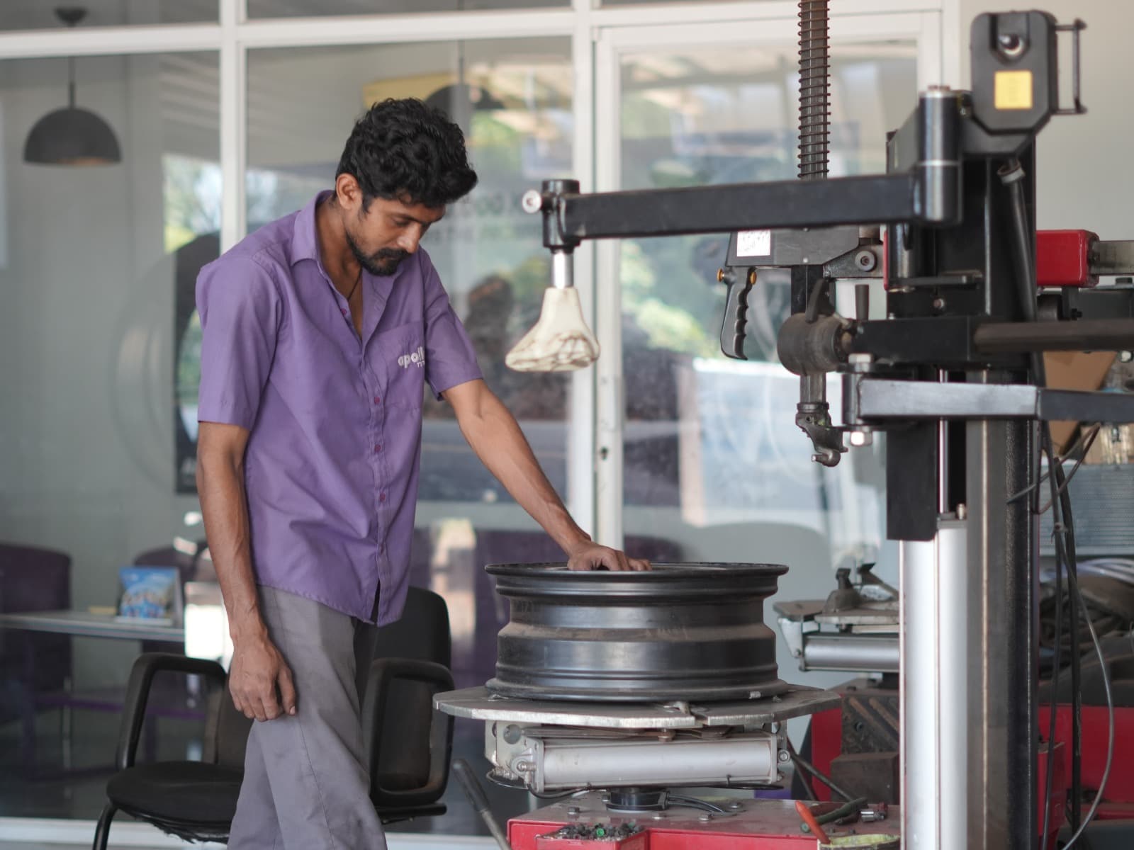 Technician balancing a wheel on the workshop floor